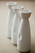 Row of white porcelain Sake bottles