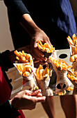 Miniportionen von Fisch und Pommes frites, serviert in Zeitungstüten auf einer Party