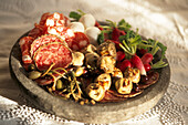 Mediterranean antipasto with various salamis artichokes caper berries quails eggs and radishes