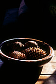 Wooden bowl filled with pine cones