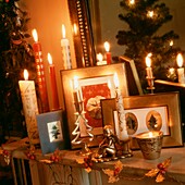 Lit candles and Christmas ornaments on mantlepiece