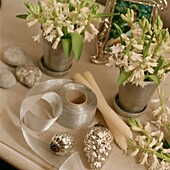 Schnittblumen und Silberband mit Silberkugeln und Kerzen