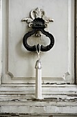 Ornate door detail with vintage iron door knocker tied with a white jewelled tassel