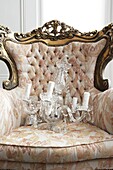 Glass chandelier on upholstered ornate rococo style armchair