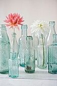 Single stem flowers in vintage bottles
