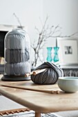 Ball of grey wool with knitting needles on coffee table in London home   UK