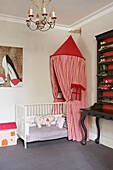 Storage solution for shoes in child's nursery with canopy over crib in London home   UK