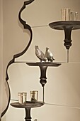 Silver bird statue and goblets on mirrored shelves in London home   UK