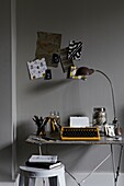 Vintage lamp and moodboard with typewriter on desk in home office