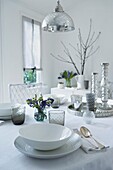 Silver candlesticks on dining table with place setting