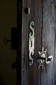 Detail of wooden door with ornate ironwork door furniture
