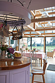 Offene Küche mit Essbereich und Sonnenzimmer in einem Landhaus in Tiverton, Devon, England, UK