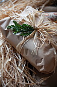 Brown wrapping paper and straw,  gift wrapped Christmas present in Benenden cottage,  Kent,  England,  UK