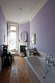 White bathtub and sink in lilac bathroom of  Greenwich home,  London,  England,  UK