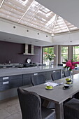 Hellgraue, offene Küche und Esszimmer in einem modernen Haus in Haywards Heath, West Sussex, England, UK