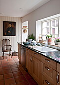 Terracotta floor in wood fitted kitchen of Ashford home,  Kent,  England,  UK