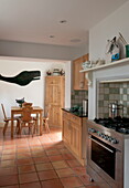 Open plan kitchen with wooden table and chairs and cut out shape of whale in Ashford home,  Kent,  England,  UK