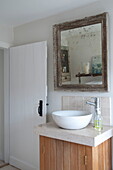Modern wash basin on wooden wash stand with vintage mirror in Kingston home,  East Sussex,  England,  UK