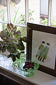 Framed print with cherries and leaf arrangement on windowsill in Kent home  England  UK