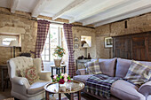 Buttoned armchair and lilac sofa in exposed stone Dordogne living room  Perigueux  France