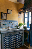 Tiled sink with yellow wall at window in  Lotte et Garonne barn conversion  France