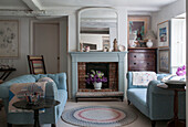 Large mirror above fireplace with light blue pair of sofas in Dorset living room  Kent  UK