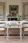 Zimmerpflanze auf dem Schreibtisch mit zwei bemalten Stühlen im Wohnzimmer des Ferienhauses in der Dordogne in Perigueux Frankreich