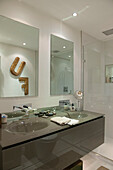 Letters 'F' and 'U' reflected above double basins of South Kensington bathroom  London  UK