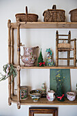 Collection of ornaments on wall mounted shelves in East Sussex coach house  England  UK