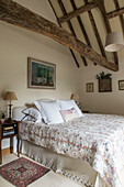 PInk quilted double bed in timber framed attic of East Sussex coach house  England  UK