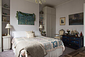 Patchwork-Bettdecke auf Doppelbett mit Kunstwerken in viktorianischem Haus im Norden Londons England UK