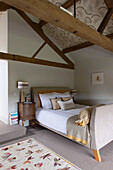 Schlittenbett unter Balkendecke in einer umgebauten Scheune in Oxfordshire, England, Vereinigtes Königreich
