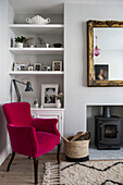 Pink armchair and shelving at fireside in  terraced house in Whitstable   Kent  England  UK