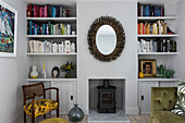 Book storage and vintage mirror in terraced house in Whitstable   Kent  England  UK