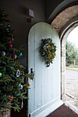 Christmas tree at arched open front door of Grade II Listed priory  Headcorn  Kent  UK