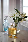 Perfume bottles and cut flowers in Brighton home, East Sussex, England, UK