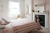 Negligee hängt am Fenster in einem Zimmer mit gestreifter Bettdecke auf einem Doppelbett in einem Haus in Brighton, East Sussex, England, UK