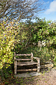 Wooden park bench in back garden of Devon home England UK