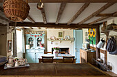 Basket hangs above wooden worktop in beamed Amberley kitchen West Sussex UK