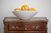 Yellow balls in bowl on antique chest of drawers in Petworth farmhouse West Sussex Kent