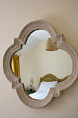 Reflection of pillows on bed in quatrefoil mirror Petworth farmhouse West Sussex Kent
