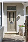 Front door of Edwardian townhouse with reclaimed stone path and oversized planters to create a modern look