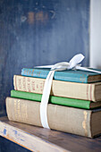 Book bundle tied with ribbon in 1950s coastal beach house West Sussex UK