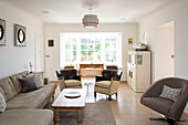 Pair of upholstered chairs with sofa and cabinet in West Wittering home West Sussex England