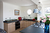 Porthole window in fitted kitchen with gas hob in West Wittering home West Sussex England