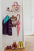 Childrenswear and umbrella in hallway of London family home  England  UK