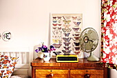 Vintage typewriter and fan on wooden chest of drawers in Birmingham home