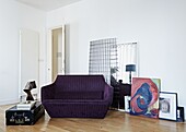 Purple two seater sofa with vintage suitcase in living room of contemporary London family home   England   UK