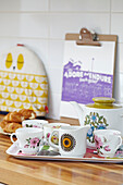 Retro style teaset with clipboard on wooden kitchen counter in London home,  England,  UK