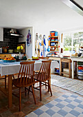 Wooden dining chairs at kitchen table in sunlit Brabourne farmhouse kitchen,  Kent,  UK